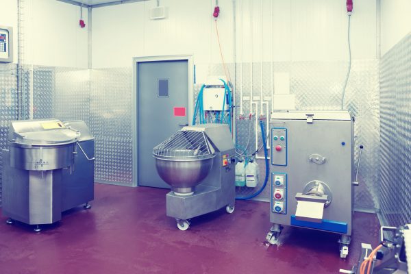 Professional meat processing equipment on food-making plant, toned image